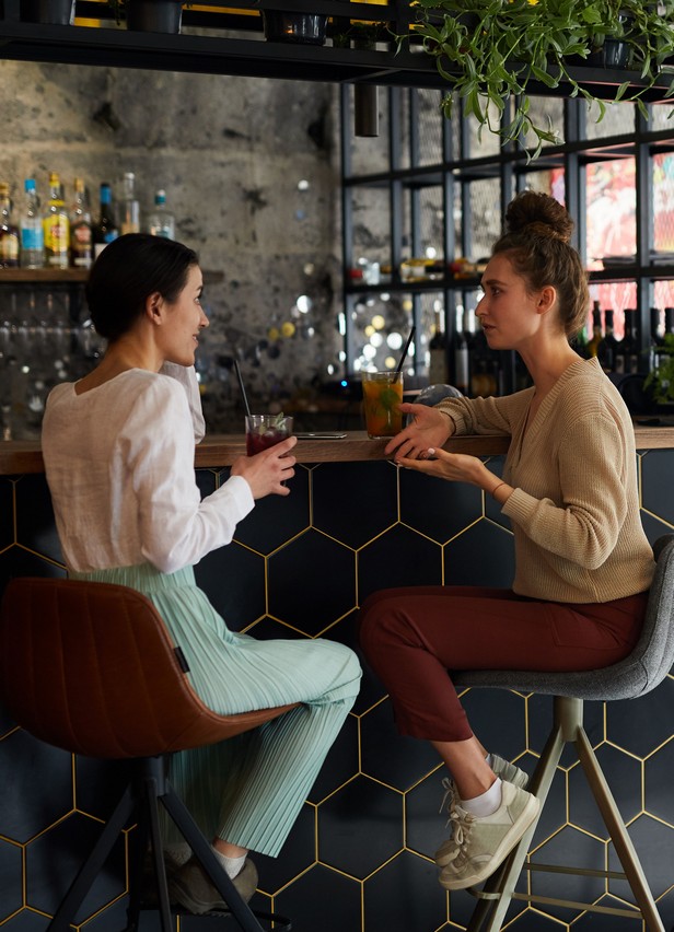 Hóspedes a conversar no bar OMID Hotels, ambiente descontraído