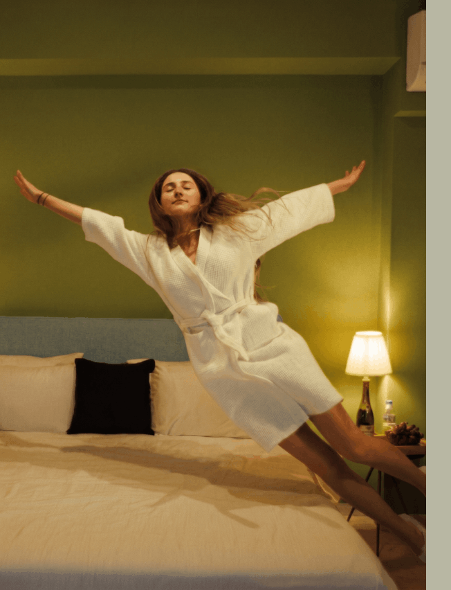 Hóspede a relaxar na cama de um quarto confortável OMID Hotels